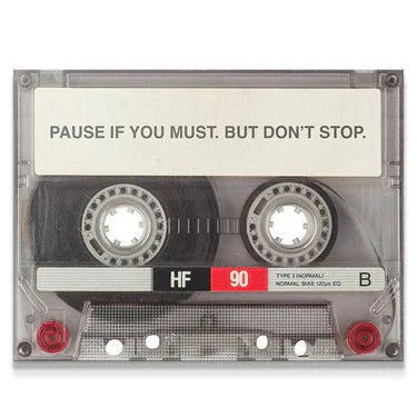 Motivational wall art featuring a cassette tape with the quote 'Pause if you must. But don't stop.'