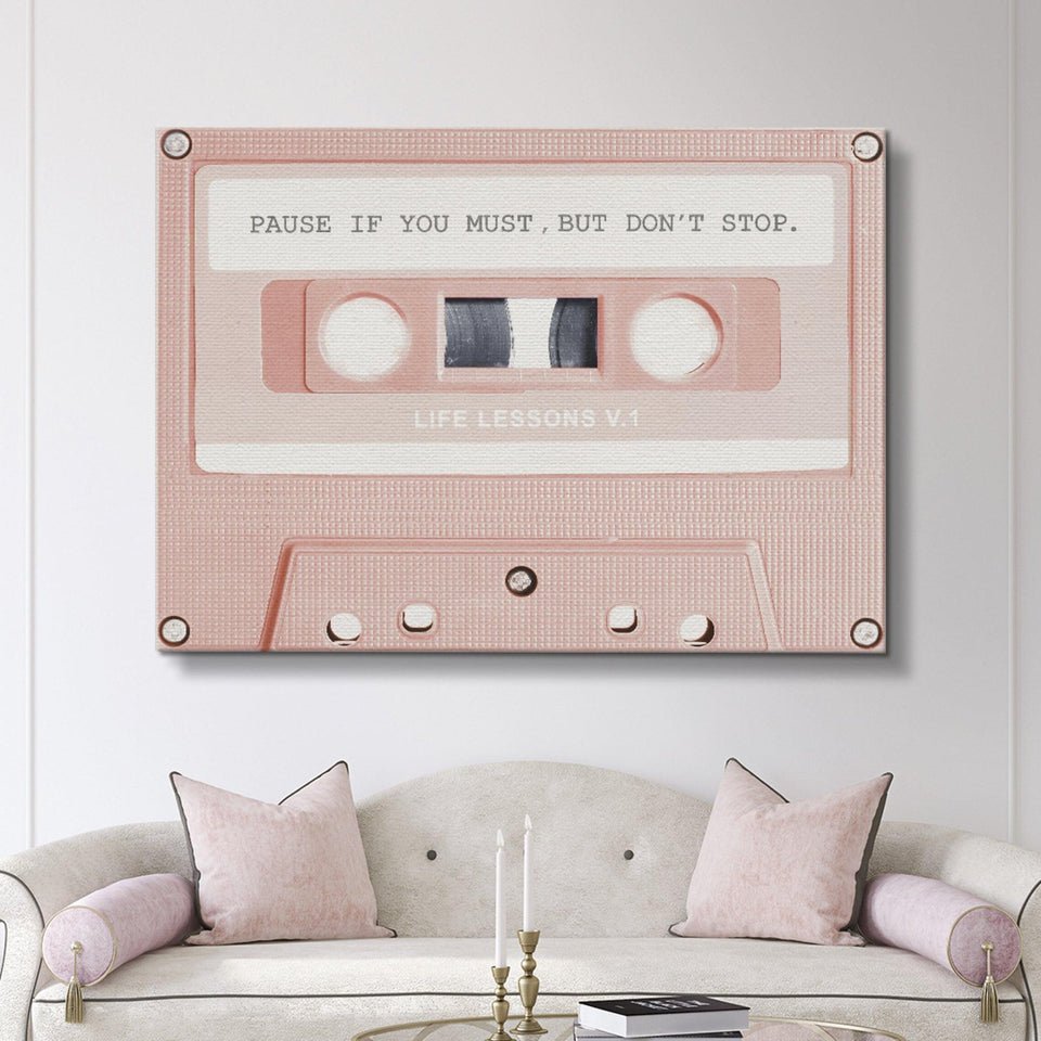 Motivational pink cassette canvas wall art with quote above a modern white sofa, IKONICK decor