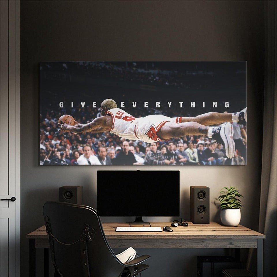 Motivational canvas wall art of a basketball player diving with 'GIVE EVERYTHING' text above desk setup.