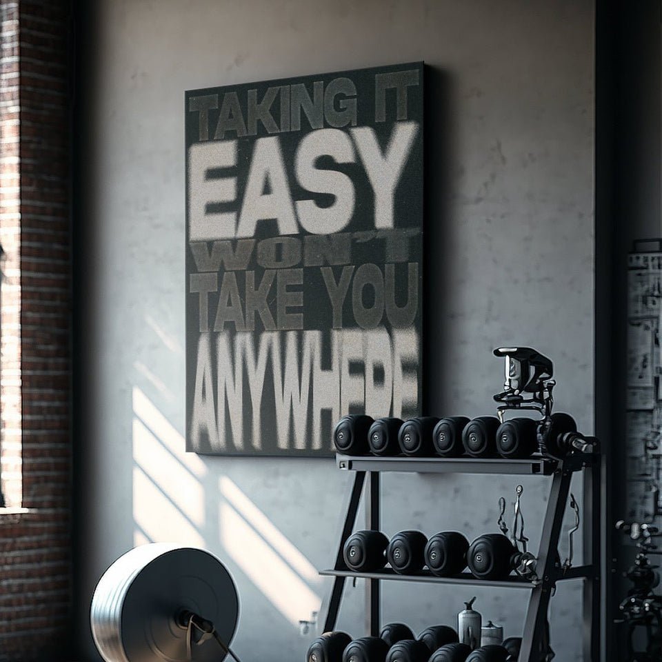 Motivational canvas wall art with 'Taking it easy won't take you anywhere' quote in modern gym.