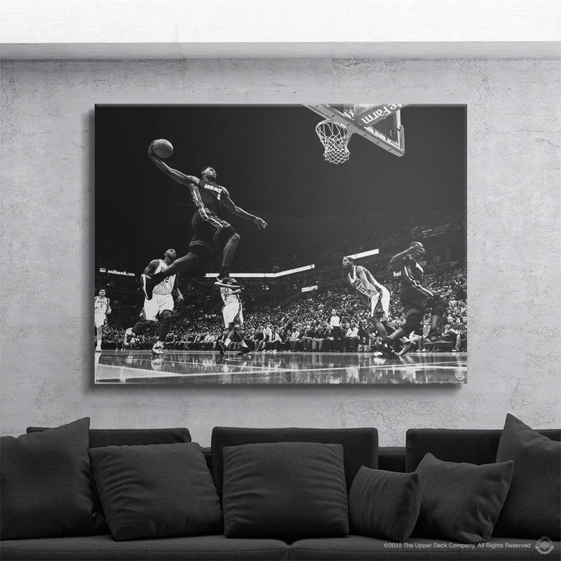 IKONICK canvas wall art of basketball player dunking, displayed above a modern sofa in living room